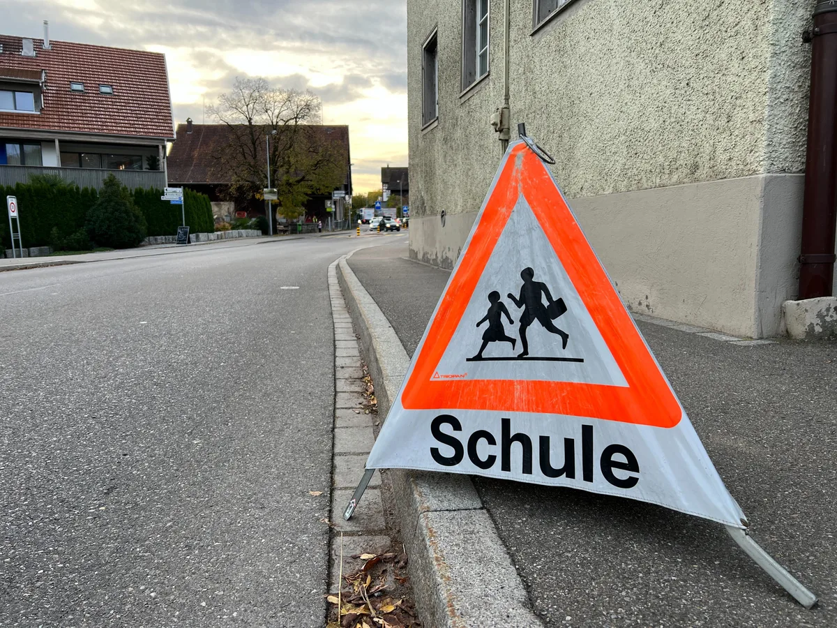Man sieht ein Triopan neben der Strasse, auf dem das Symbol für «Vorsicht Schulweg» abgebildet ist.